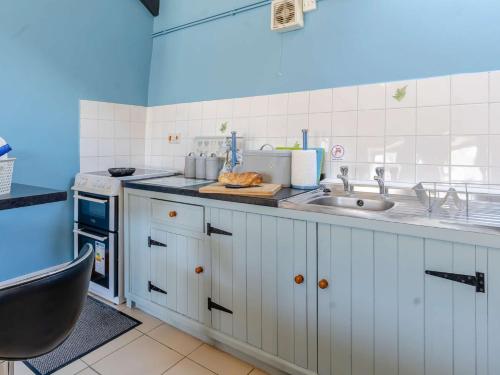 a kitchen with white cabinets and a sink at 1 bed property in Brynteg 81354 in Llanwenog