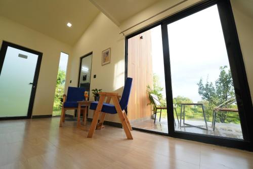 a room with a table and chairs and a large window at The Solace Bir in Bīr
