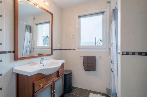 ein Bad mit einem Waschbecken und einem Spiegel in der Unterkunft Maison vue mer 150m de la plage in Trégunc