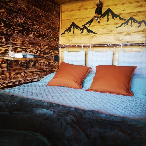 a bed with two orange pillows in a room at Casas D'Aldeia Arcos de Valdevez in Arcos de Valdevez