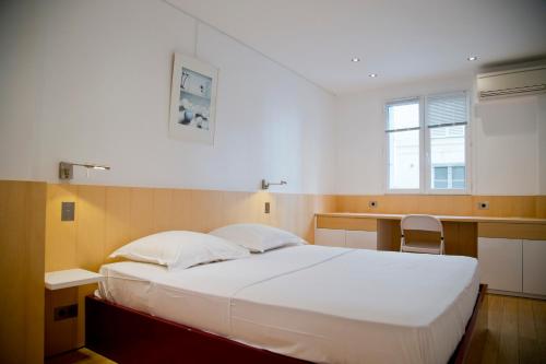 une chambre avec un grand lit blanc et une fenêtre dans l'établissement TASTY LUXURY 3 BEDROOM FULL VIEW SEINE-NOTRE DAME, à Paris