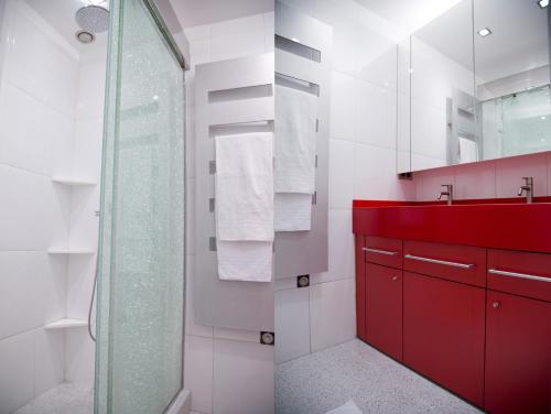 La salle de bains est pourvue d'un lavabo rouge et d'une douche. dans l'établissement TASTY LUXURY 3 BEDROOM FULL VIEW SEINE-NOTRE DAME, à Paris