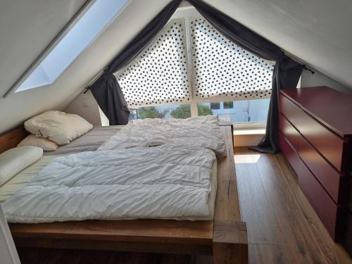 ein großes Bett in einem Zimmer mit Fenster in der Unterkunft Ferienhaus Bojenweg in Rostock
