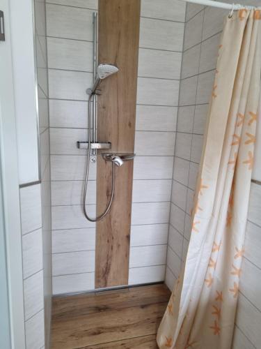 um chuveiro na casa de banho com uma cortina de chuveiro em Ferienhaus Bojenweg em Rostock