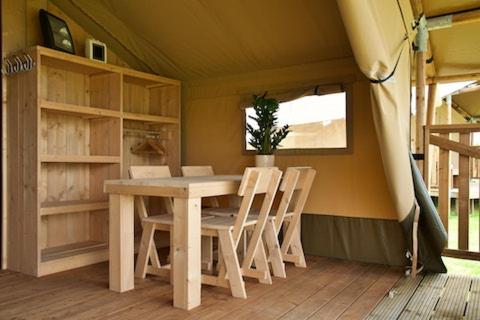 a dining room with a table and chairs in a house at Recreatiepark de Meibeek in Ruurlo