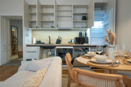 uma cozinha e sala de estar com uma mesa e um sofá em Brand-new 2-room apartment in a top location em Viena