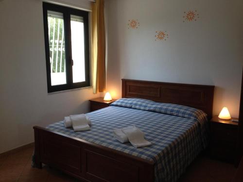 um quarto com uma cama com duas toalhas brancas em Villa Patrizia - Residence La Giungla em Falerna