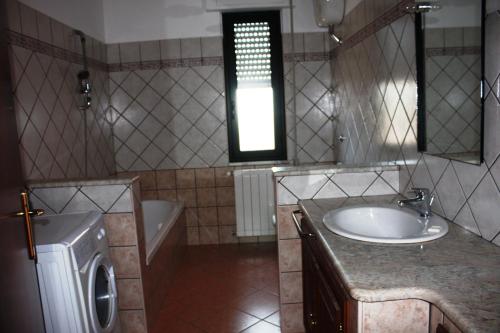 uma casa de banho com um lavatório e uma máquina de lavar roupa em Villa Patrizia - Residence La Giungla em Falerna