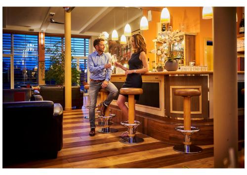 a man and a woman standing at a bar at Vitalhotel Bad Birnbach in Bad Birnbach