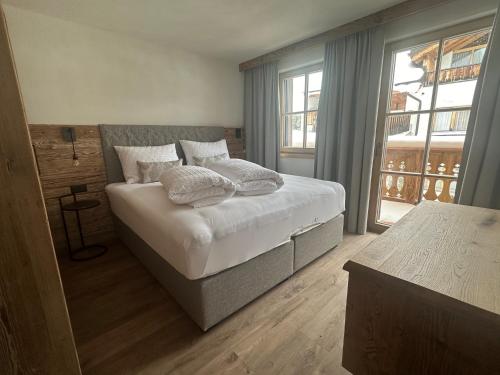 1 dormitorio con cama con almohadas y ventana en Samnaun, ChaletdMot, en Samnaun