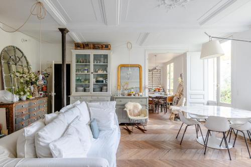 a living room with a white couch and a table at Veeve - Artist's Imprint in Paris