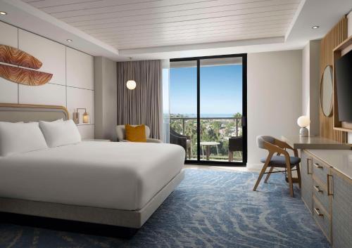 a hotel room with a bed and a large window at Hotel La Jolla, Curio Collection by Hilton in San Diego