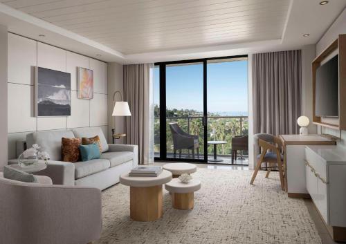 a living room with a couch and a table at Hotel La Jolla, Curio Collection by Hilton in San Diego