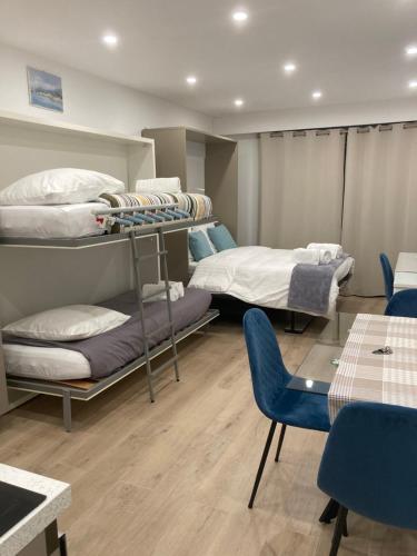 Cette chambre comprend 2 lits superposés, une table et des chaises. dans l'établissement Studio La Cigale bord de mer, à Menton