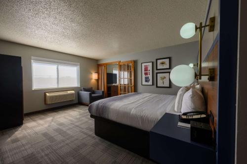 pokój hotelowy z łóżkiem i oknem w obiekcie AmericInn by Wyndham Monroe w mieście Monroe
