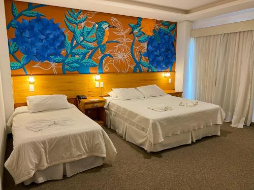 una habitación de hotel con 2 camas y un cuadro en la pared en Los Lagos Resort Hotel, en Capiatá