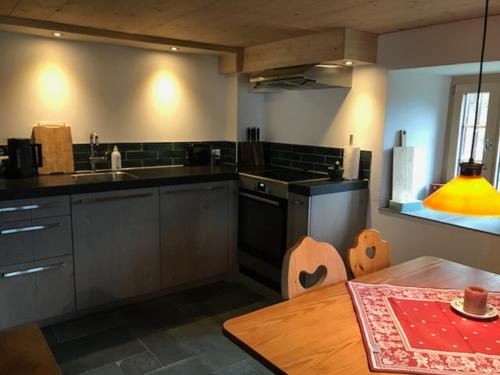 a kitchen with a table and a sink and a stove at Casa Vanellus / Vignogn / Val Lumnezia / near Laax in Vigens