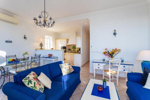 un salon avec un canapé bleu et une cuisine dans l'établissement VOLTI ON THE BAY AP4386 By Riviera Holiday Homes, à Villefranche-sur-Mer