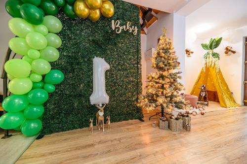 a christmas party with a green wall and a christmas tree at Safari Family Villas near Park Aventura,Lake,Zoo in Braşov