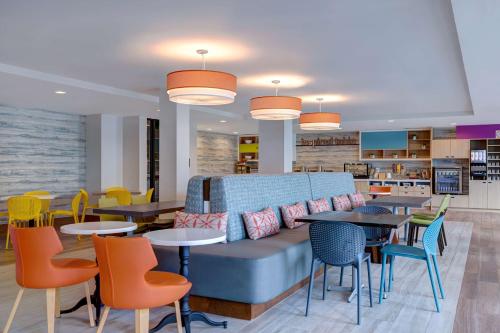 a lobby with a couch and tables and chairs at Home2 Suites By Hilton Anaheim Resort in Anaheim