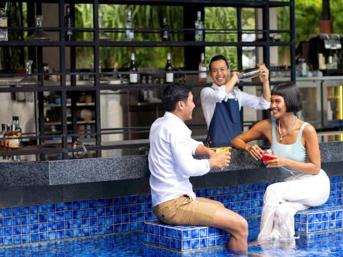 un gruppo di tre persone seduti in piscina di Grand Mercure Bali Seminyak a Seminyak