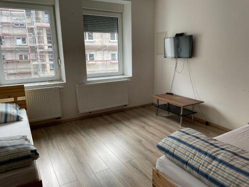 a room with two windows and a tv on the wall at Monteur-Apartment am Bahnhof in Muhlheim am Main