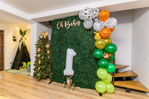 a green wall with a number sign and balloons at Jungle Family Villa near Park Aventura,Lake,Zoo in Braşov