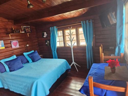 Un dormitorio con una cama azul y una ventana en La Maxada Luz Maria en El Cotillo