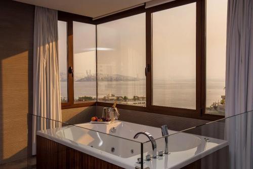 a bathroom with a large tub in front of a window at Opera Hotel 