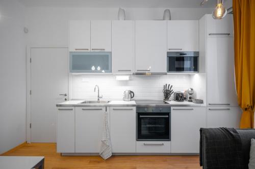 a kitchen with white cabinets and a sink at Modern 2BD Flat with Prime Location and Workspace in Sofia