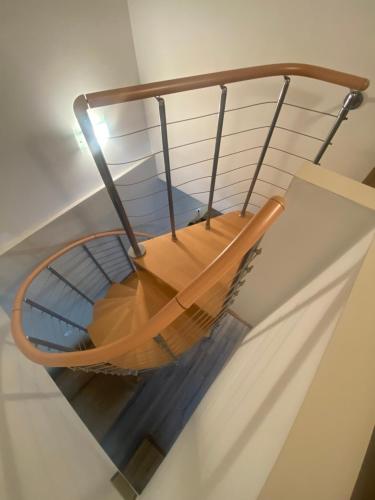 a spiral staircase in a building with a wooden seat at Villas de La Ferme Du Gros Noyer in Malaucène