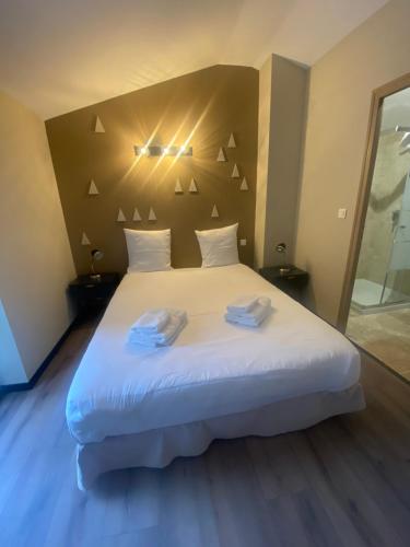 a bedroom with a large bed with two towels on it at Villas de La Ferme Du Gros Noyer in Malaucène