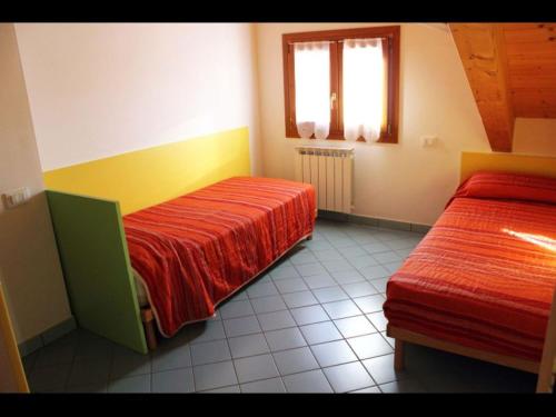1 dormitorio con 2 camas y ventana en Adorable flat with attic in residence, en Rosapineta