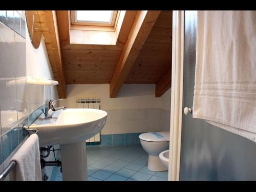 a bathroom with a sink and a toilet at Adorable flat with attic in residence in Rosapineta