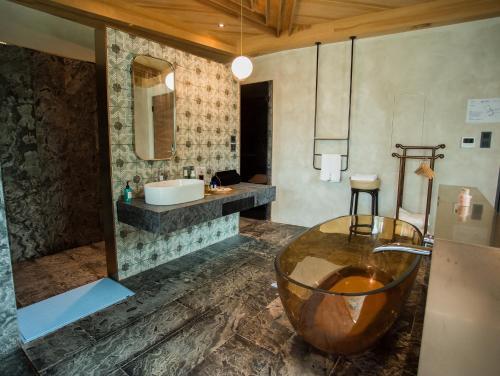 a bathroom with a large bowl sink and a tub at The Forest Museum in Zhuolan