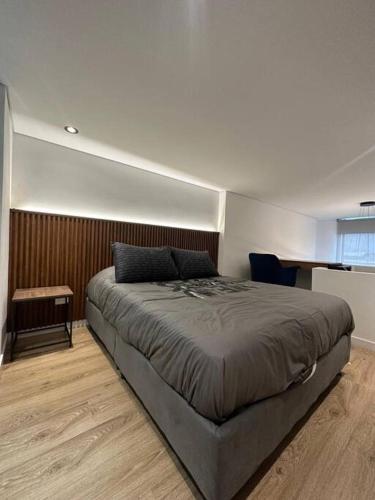 1 dormitorio con 1 cama grande y 1 mesa en Luxury apto doble altura Bogotá en Bogotá