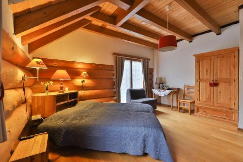 a bedroom with a bed and a desk and a chair at Chambres d'hôtes Les Rondins De La Fecht in Mittlach