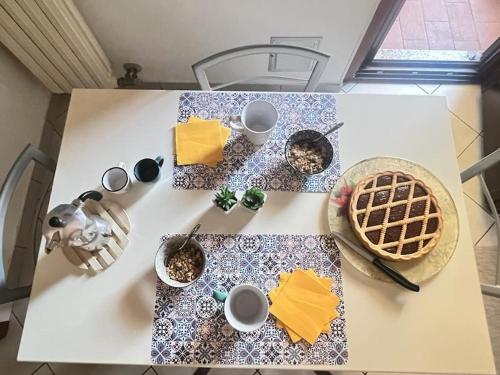 una mesa con tazas y una cesta de comida. en Grace's House - Milan & Rho Fiera, en Vittuone