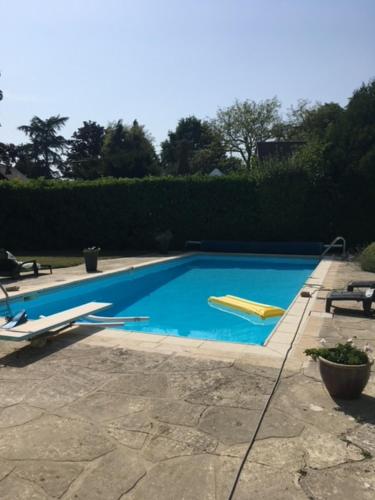 une piscine bleue avec un objet jaune dans l'établissement ENOLAND La maison du bonheur, à Bourdonné