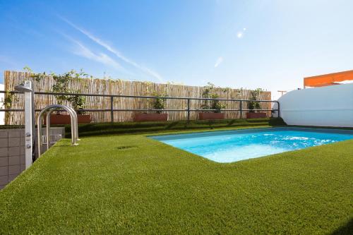- une piscine dans une cour avec une clôture dans l'établissement Veoapartment Relator Terraza, à Séville