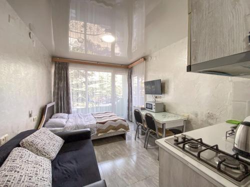 a living room with a kitchen and a bedroom at уютная студия Maksim in Batumi