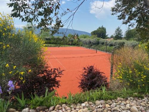 an orange fence in the middle of a garden at Résidence hôtelière et SPA des sources du gros noyer in Malaucène