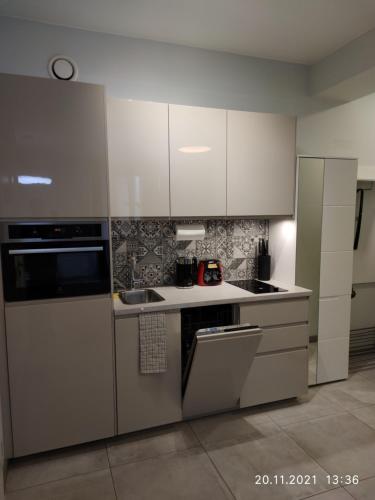 a kitchen with stainless steel appliances and white cabinets at Lovely condo in the heart of Warsaw Piękne mieszkanie w samym sercu Warszawy in Warsaw