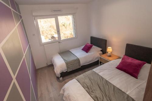 a small bedroom with two beds and a window at La Niche 2 in Brides-les-Bains