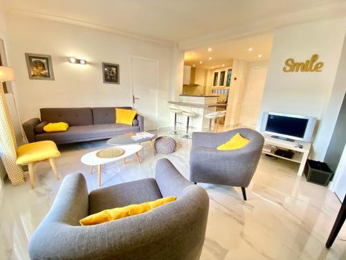 un salon avec des canapés, des chaises et une télévision dans l'établissement La Rotonde By SCLS Locations, à Cannes