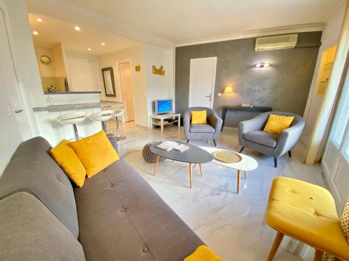 un salon avec un canapé, des chaises et une table dans l'établissement La Rotonde By SCLS Locations, à Cannes