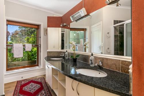 łazienka z umywalką i dużym lustrem w obiekcie Pezula Secure Tranquility w mieście Knysna