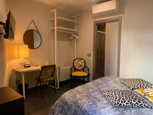 a bedroom with a bed and a desk and chairs at La Forgia in Grosseto
