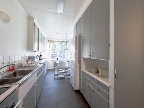 a white kitchen with white cabinets and a sink at Strandgården Karlstad in Karlstad