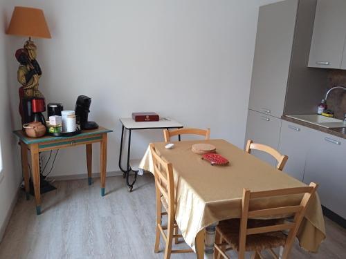 une cuisine avec une table, deux chaises, une table et un comptoir dans l'établissement LE 57 VICHY, à Vichy